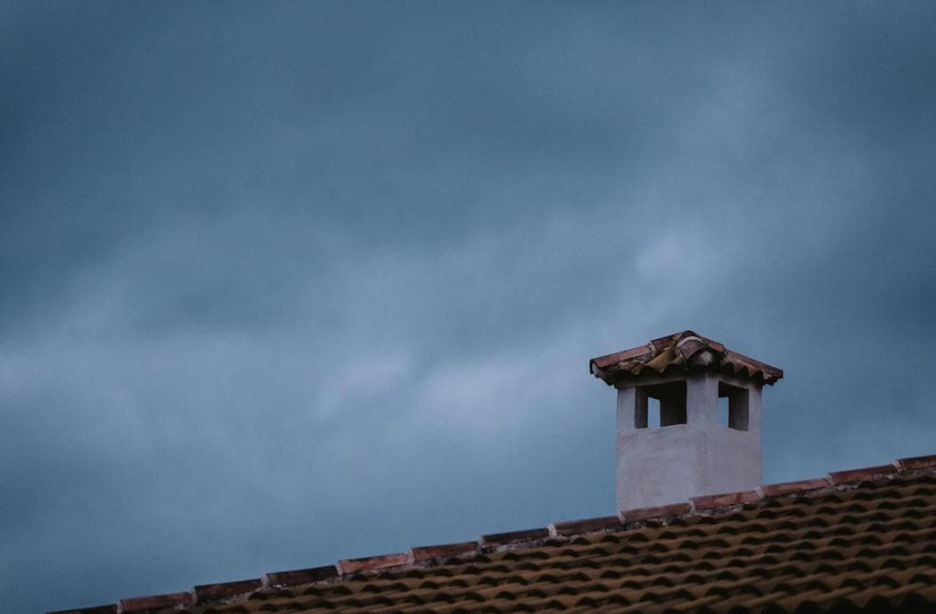 A chimney on a tiled roof and a blue sky